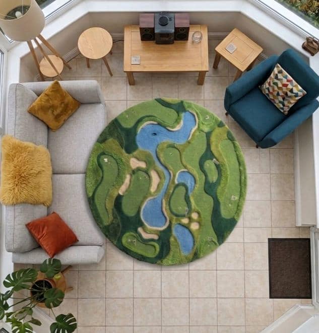 Shubham-Art-Rugs-hand-tufted-golf-course-rug-new-zealand-wool-3d-topography-sports-room-decor A round area rug with a golf course landscape design in shades of green, blue, and beige, styled in a bright modern living room setting.