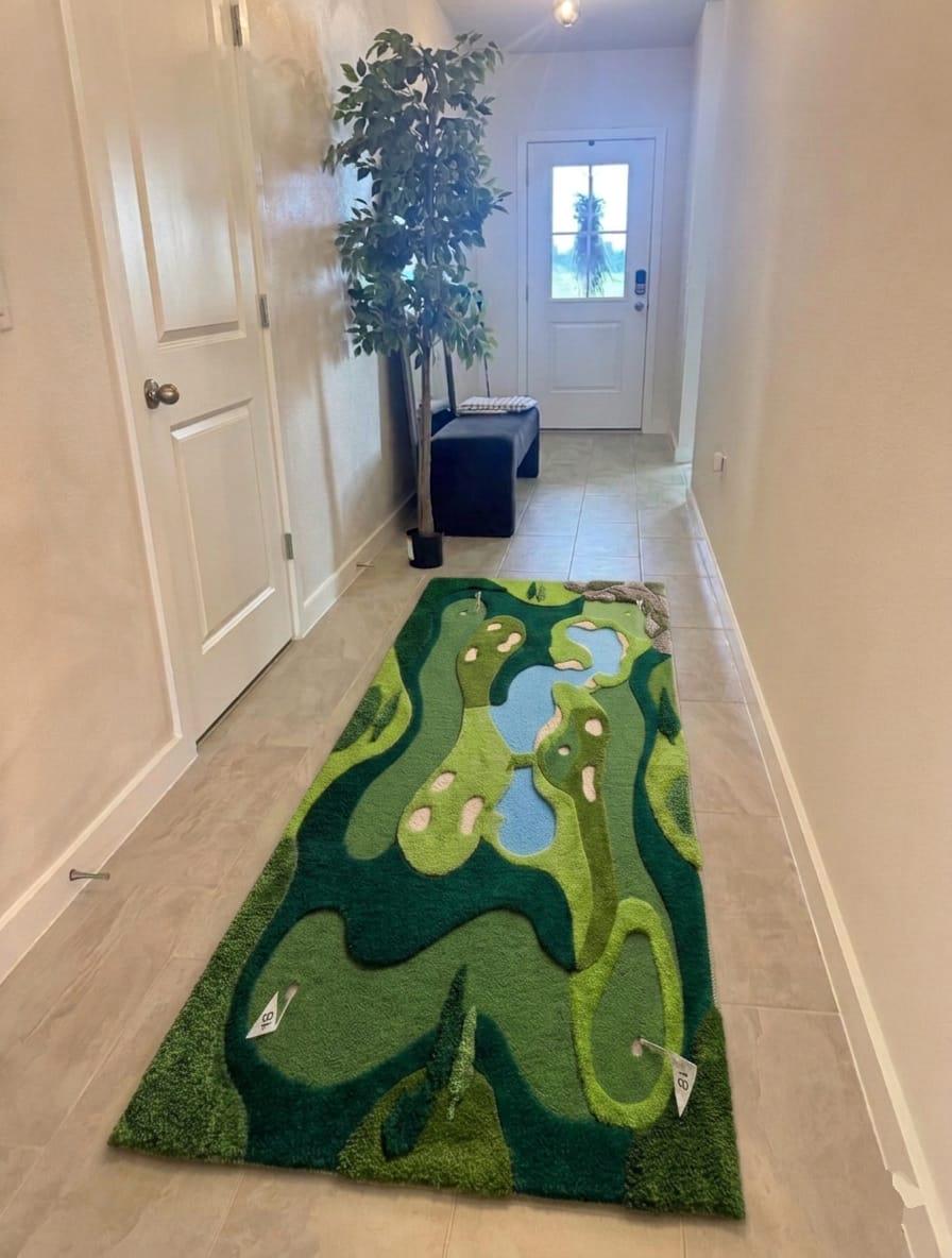 Shubham-Art-Rugs-hand-tufted-new-zealand-wool-golf-course-rug-novelty-sports-area-decor A long rectangular golf course rug with raised green, blue, and beige terrain details, displayed on a light wood floor in a hallway.