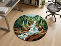 Rustic-lodge-bedroom-interior-styling-with-premium-round-handmade-wool-nature-landscape-carpet  A round area rug featuring a colorful landscape illustration of a waterfall, pine trees, and a flowing river, displayed on a light wood floor in a modern office setting.