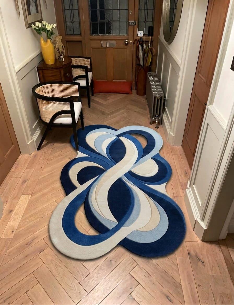 Shubham-Art-Rugs-hand-tufted-new-zealand-wool-rug-blue-abstract-organic-modern-area-carpet A modern abstract area rug with a layered, knot-like design in shades of blue, navy, light blue, and cream, displayed on a herringbone wood floor in a hallway setting.