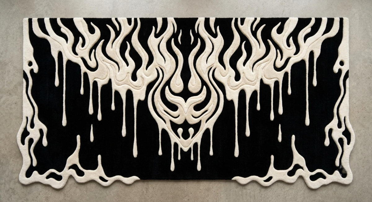 Modern-gothic-bedroom-living-room-interior-styling-featuring-luxury-monochrome-fluid-drip-irregular-area-carpet A rectangular black rug with a raised cream-colored dripping flame or melting design, photographed from above on a light gray textured floor.